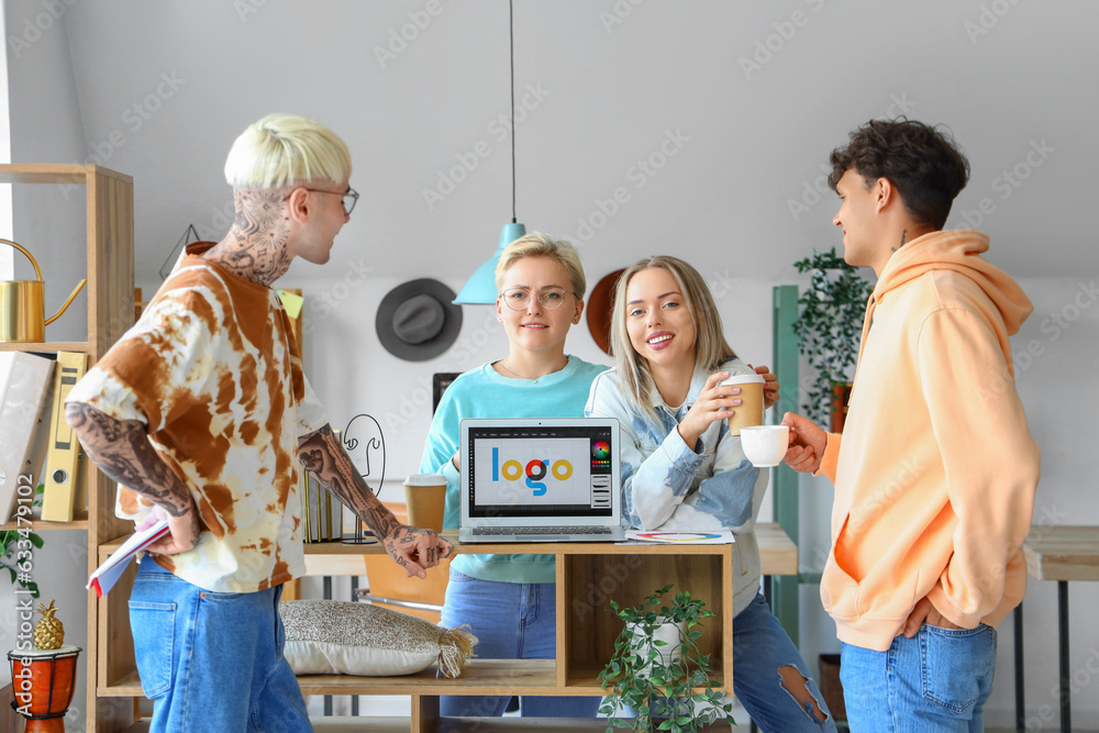 Team of graphic designers with cups of coffee working in office