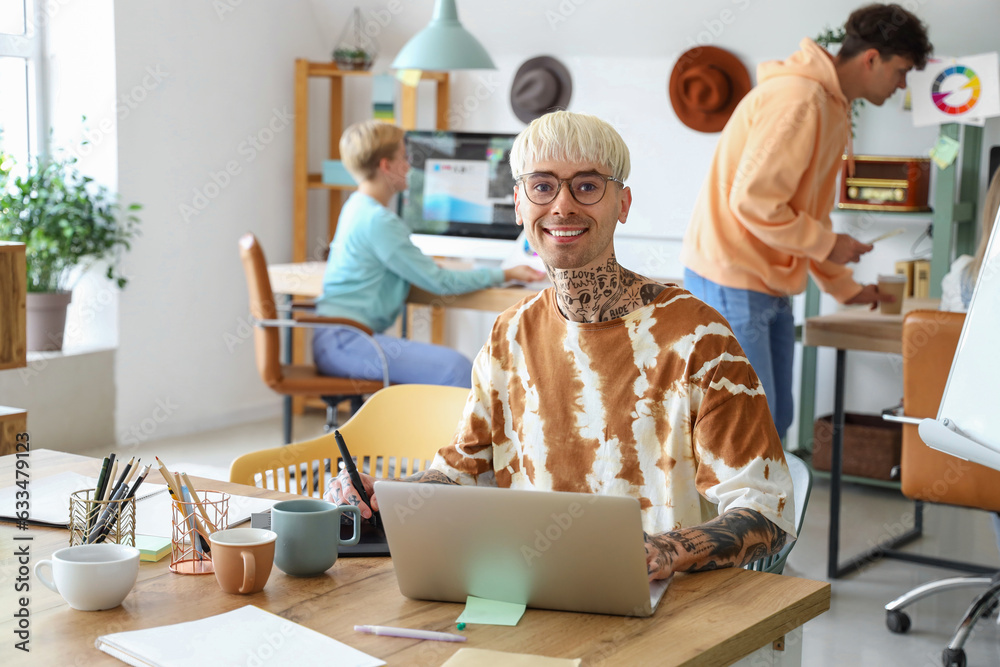 Male graphic designer working with tablet at table in office