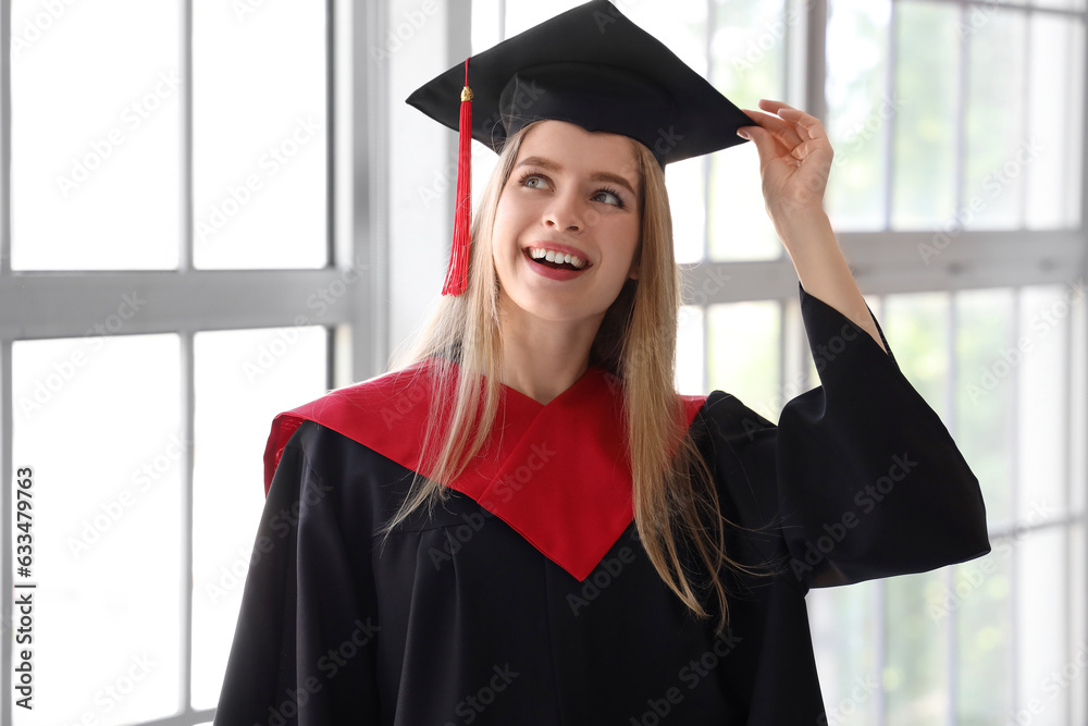 Female graduate student near window in room