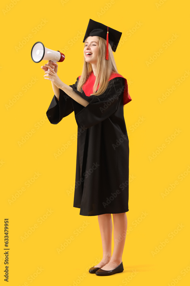 Female graduate student shouting into megaphone on yellow background