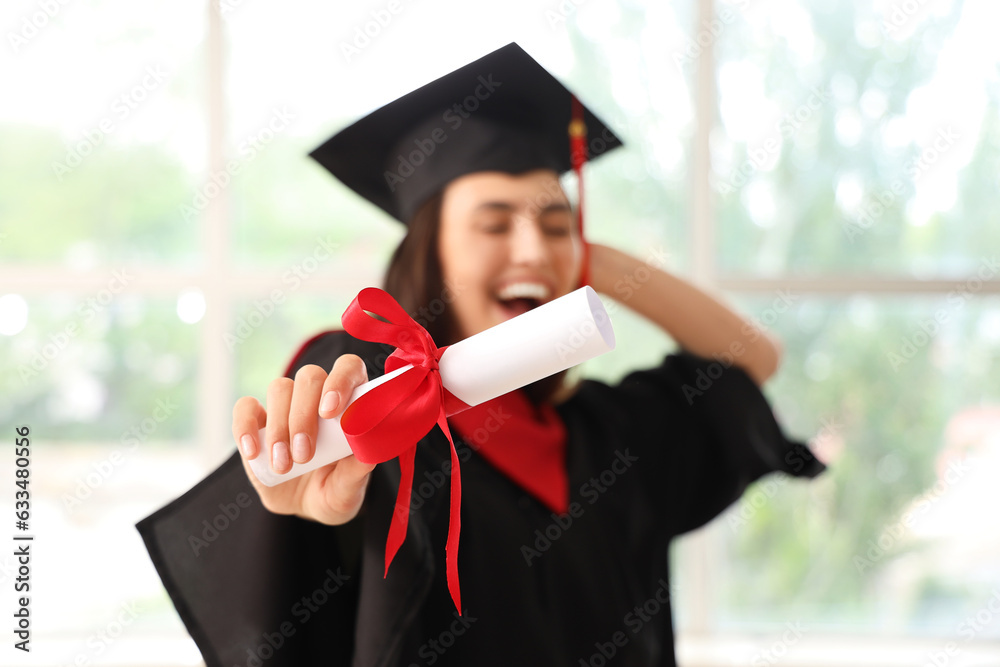 Female graduate student with diploma near window in room, closeup