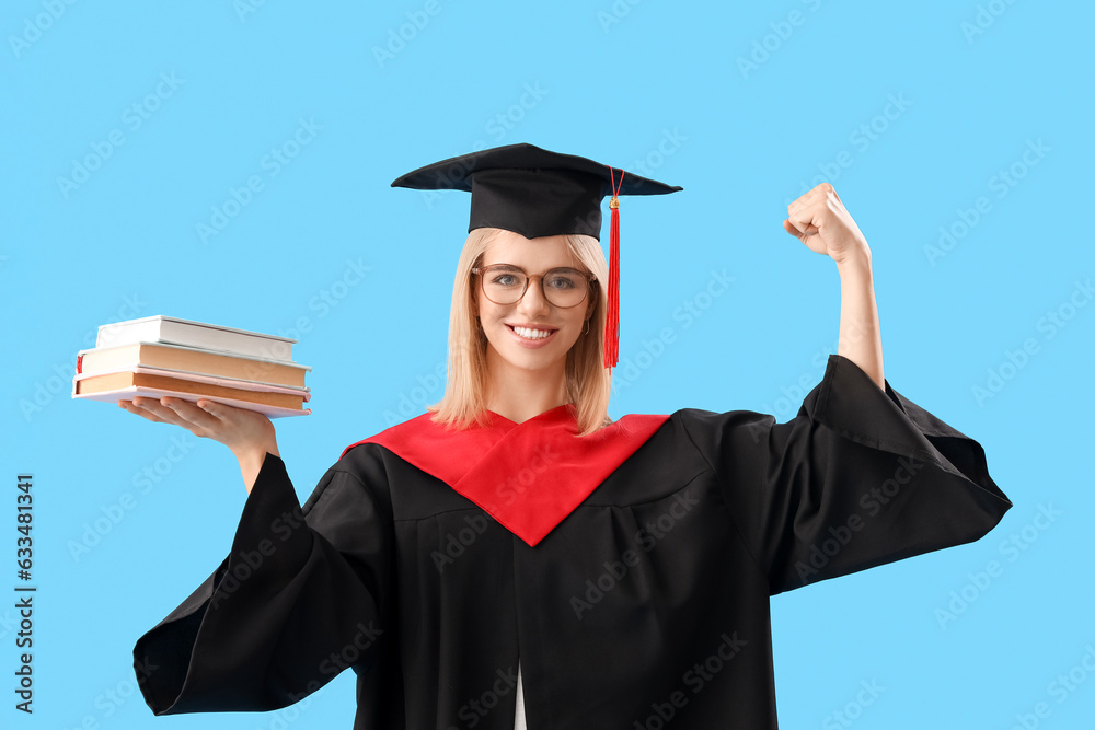 Female graduate student with books showing muscles on blue background