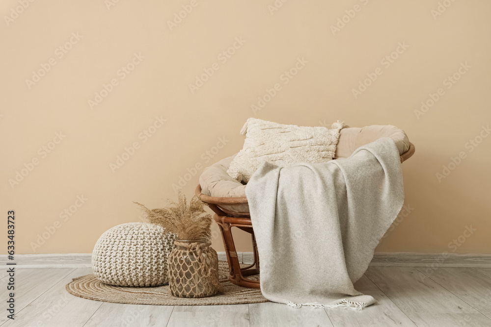 Interior of living room with plaid on armchair and pouf