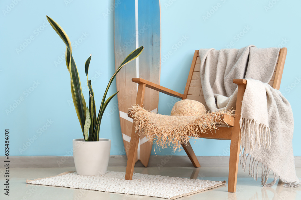 Interior of living room with surfboard and plaid on armchair