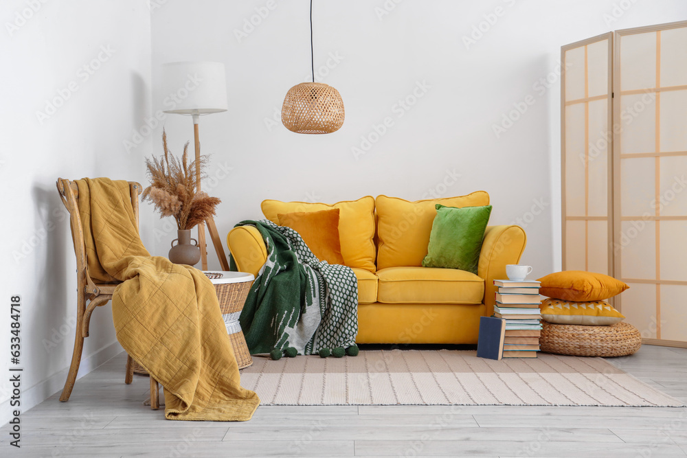 Interior of living room with sofa, stool and plaids