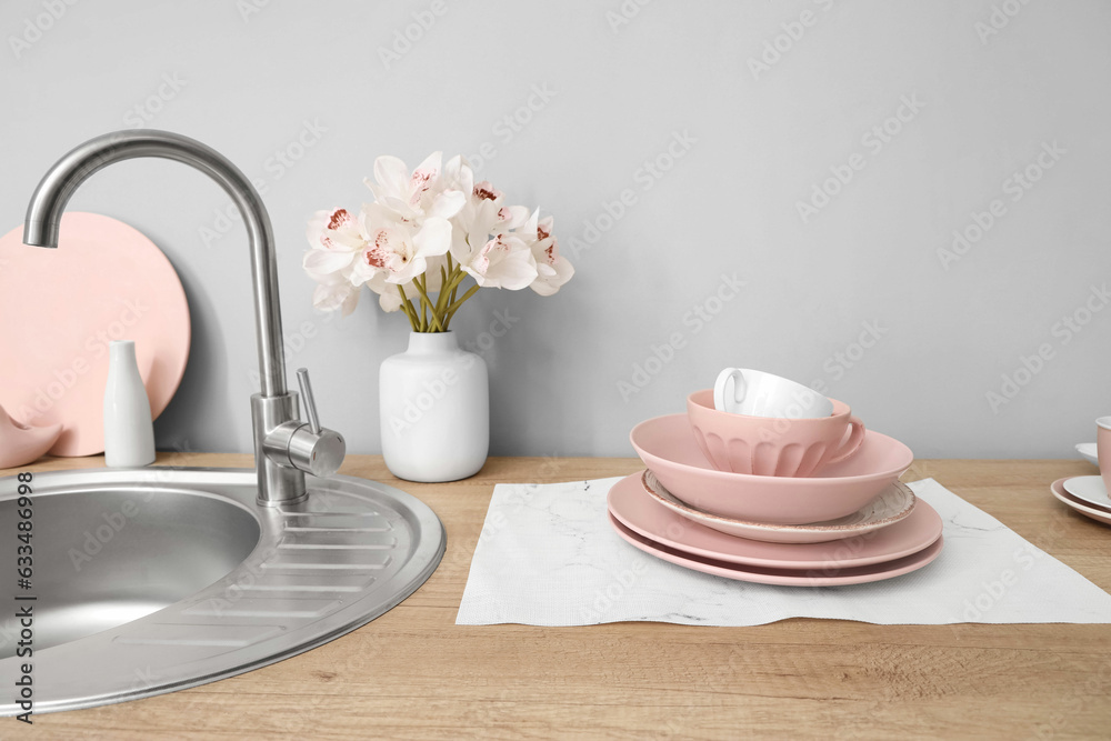 Kitchen counter with clean dishes, sink and orchid flowers