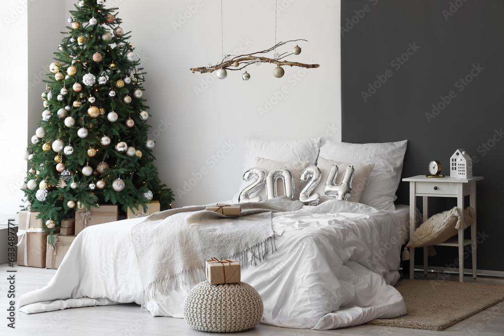 Balloons in shape of figure 2024 on comfortable bed in bedroom with Christmas decor