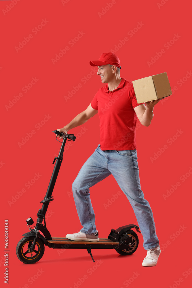 Mature courier with parcel and electric bike on red background