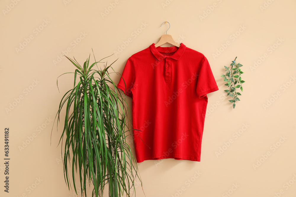 Stylish red t-shirt hanging on beige background