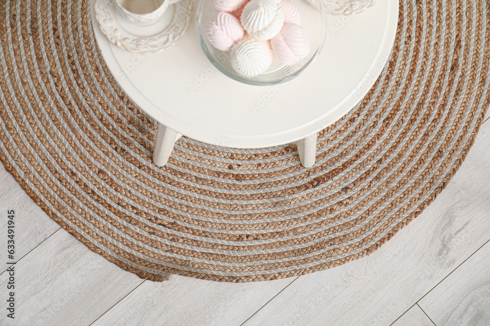 Small table with tea set and zephyr on wicker rug in kitchen, closeup