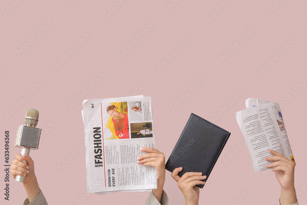 Female hands with newspapers, notebook and microphone on color background