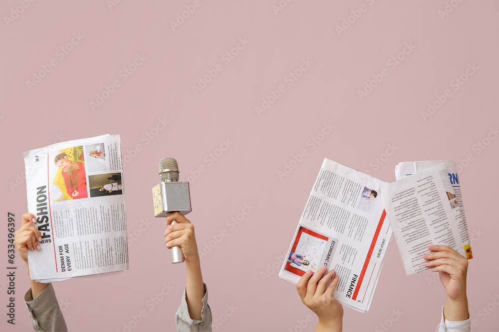 Female hands with newspapers and microphone on color background