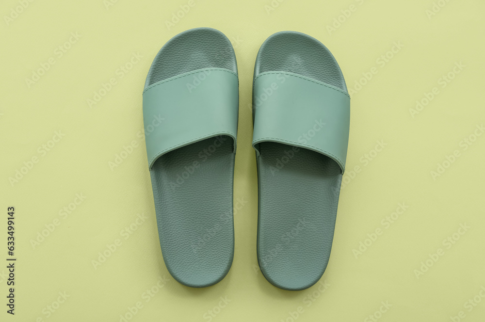 Pair of flip flops on green background