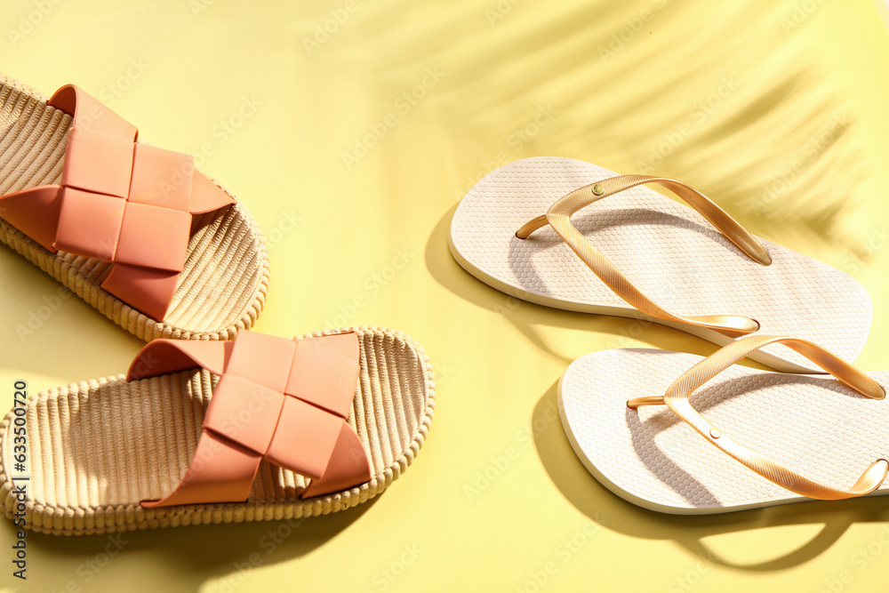 Female stylish flip flops on yellow background