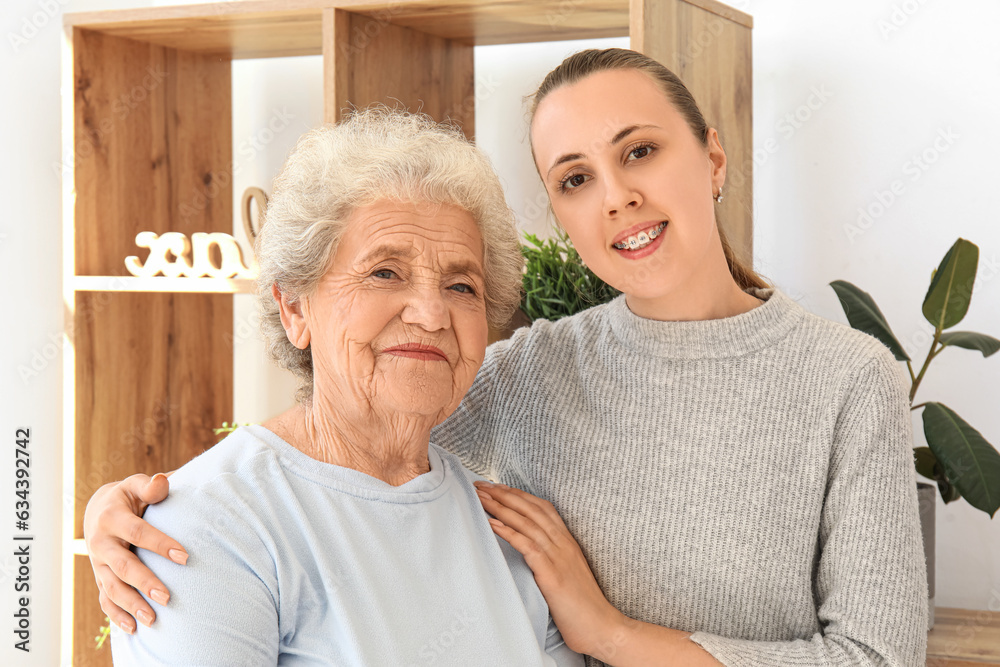 Senior woman with her granddaughter hugging at home