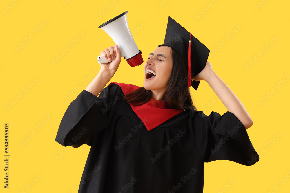 Female graduate student shouting into megaphone on yellow background