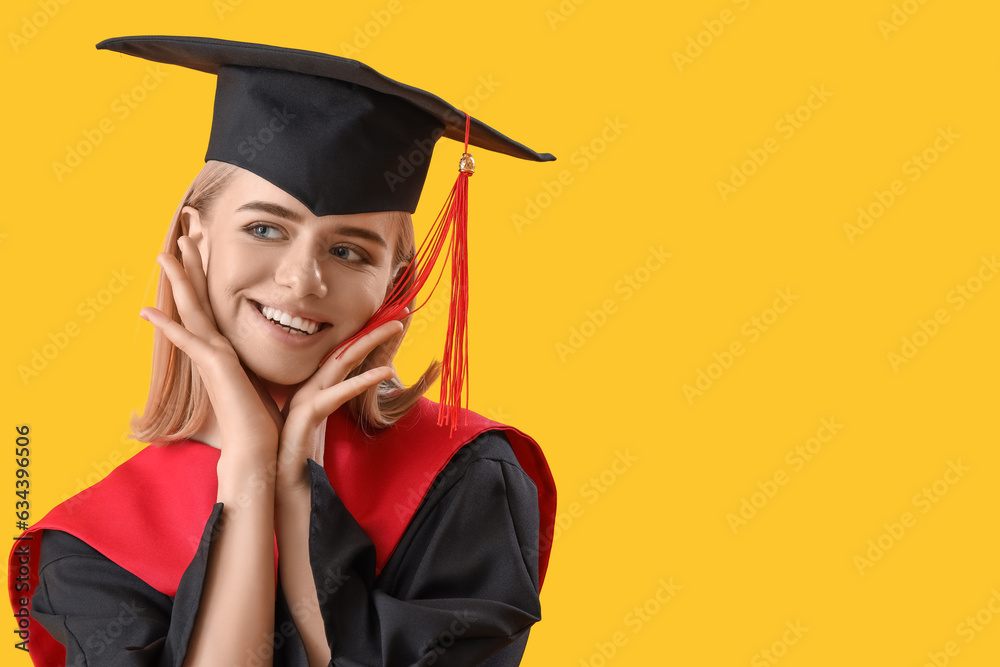 Happy female graduate student on yellow background, closeup