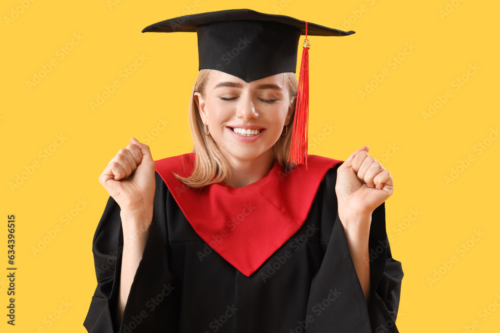 Happy female graduate student on yellow background, closeup