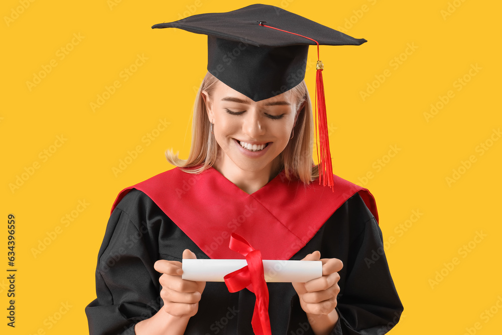 Female graduate student with diploma on yellow background