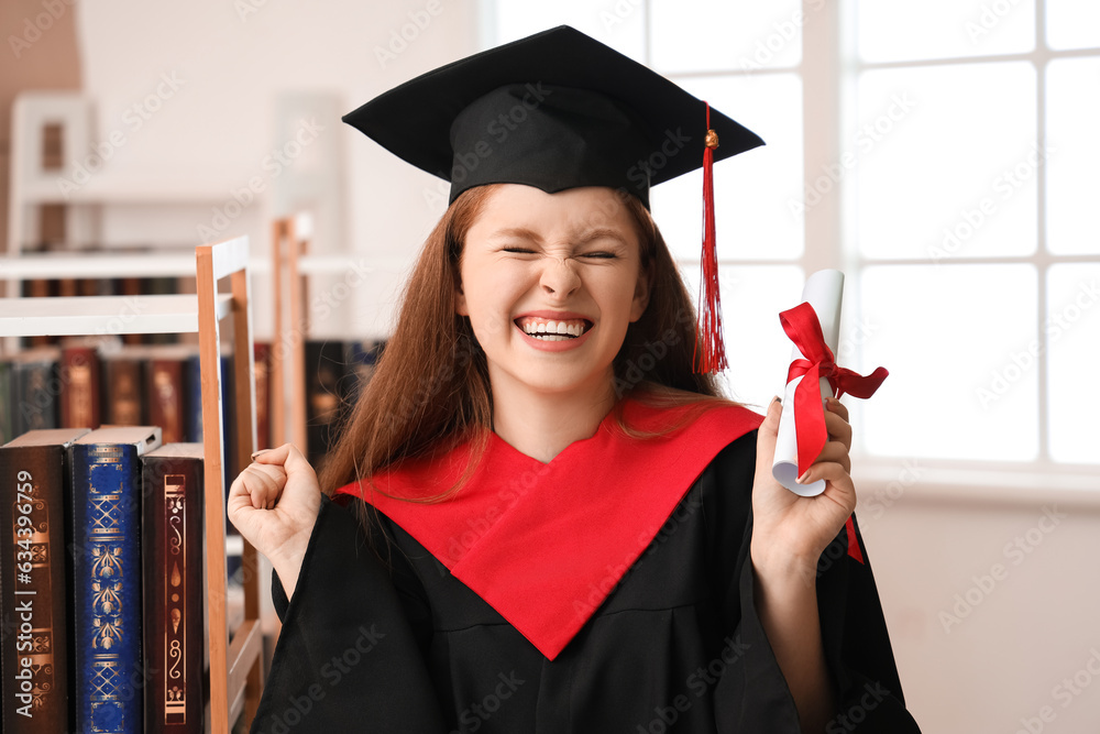 Happy female graduate student with diploma in library