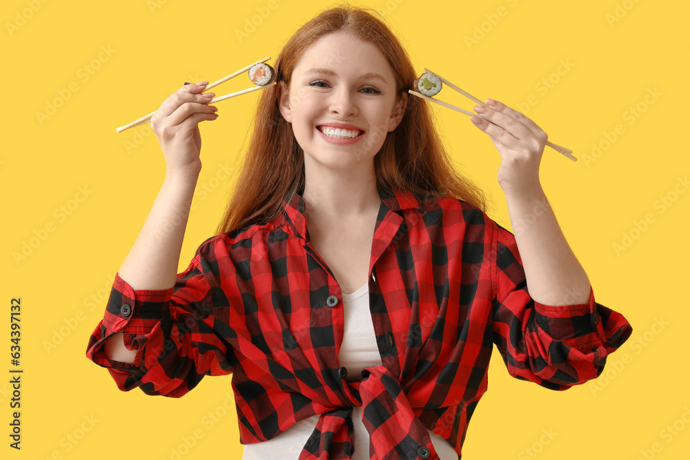 Young woman with tasty sushi rolls on yellow background