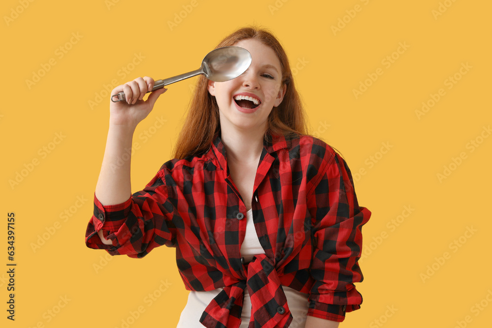 Young woman with ladle on yellow background