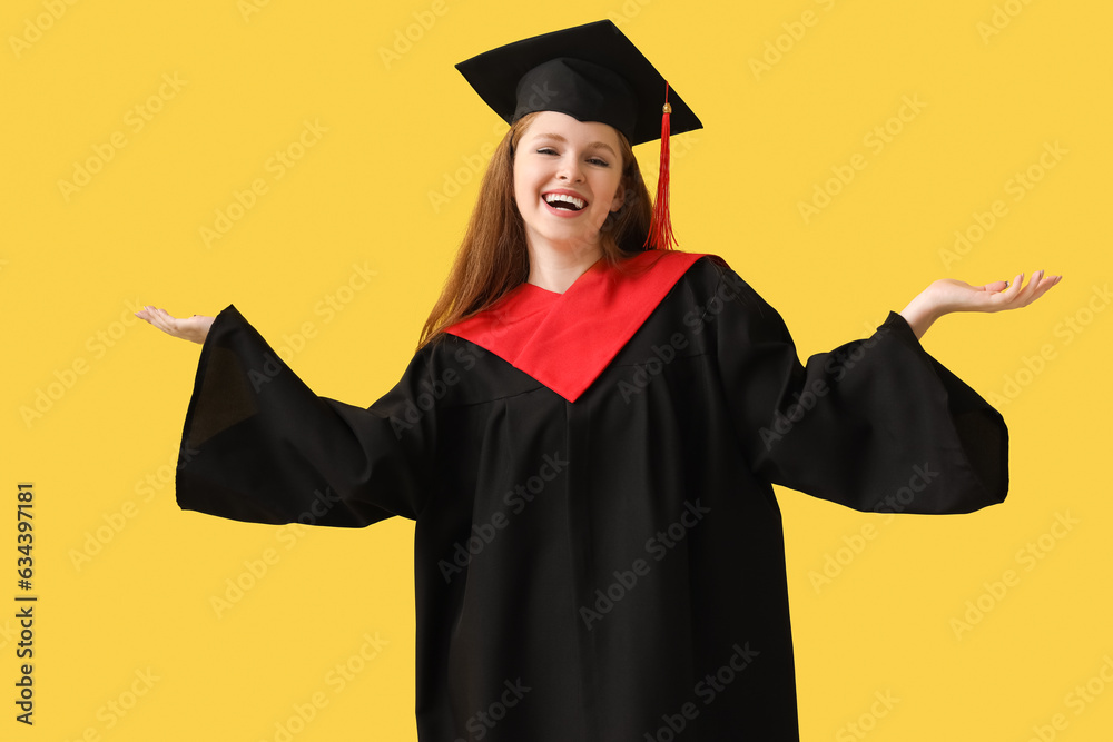 Happy female graduate student on yellow background