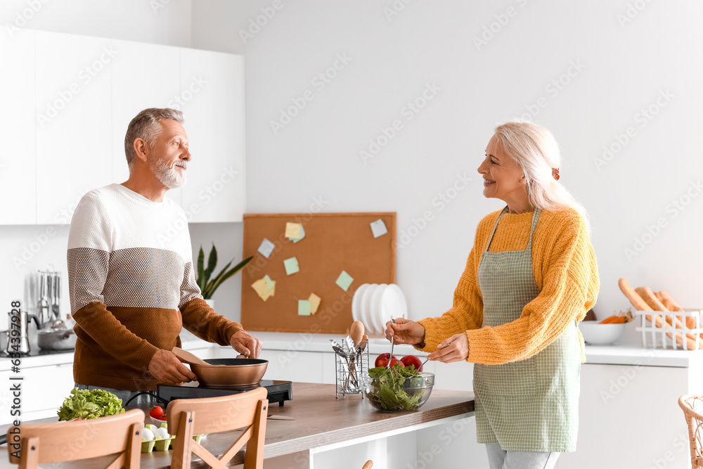 Mature couple cooking in kitchen