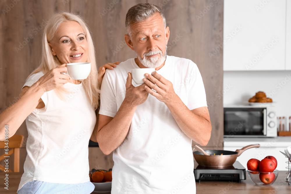 Mature couple drinking coffee in kitchen