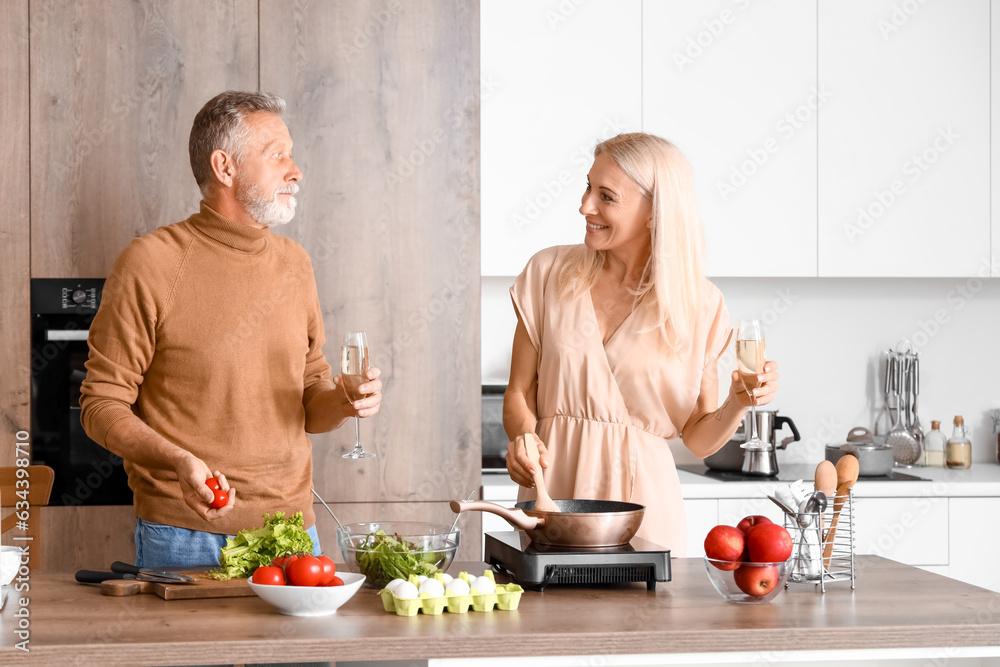 Mature couple drinking champagne in kitchen