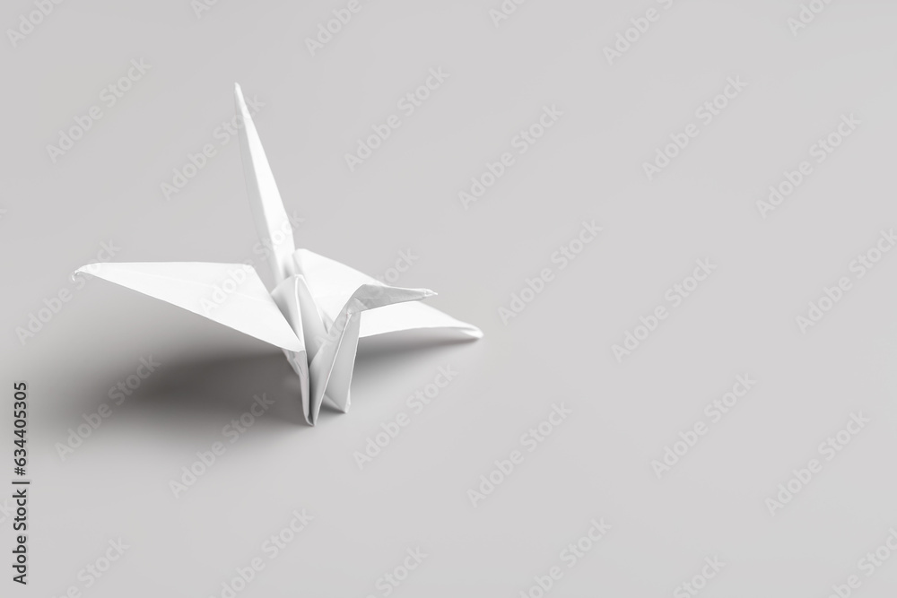 Origami crane on grey background