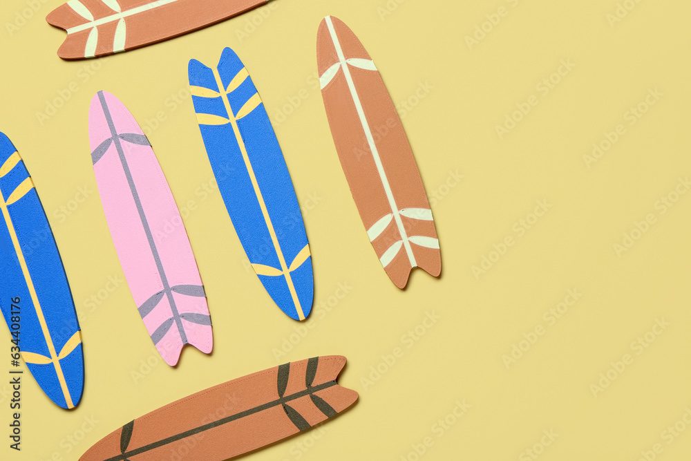 Different mini surfboards on yellow background