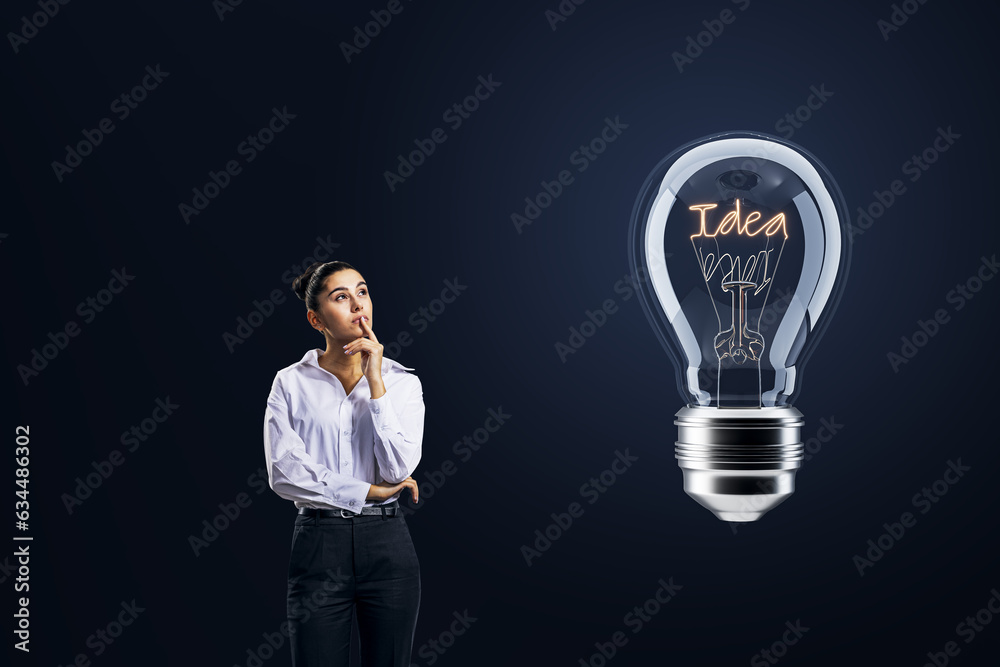 Thoughtful businesswoman looking at light bulb on dark background. Idea concept