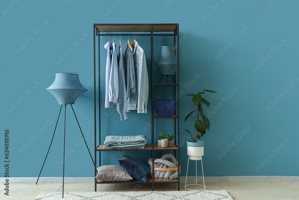 Interior of dressing room with shelving unit, clothes and lamps