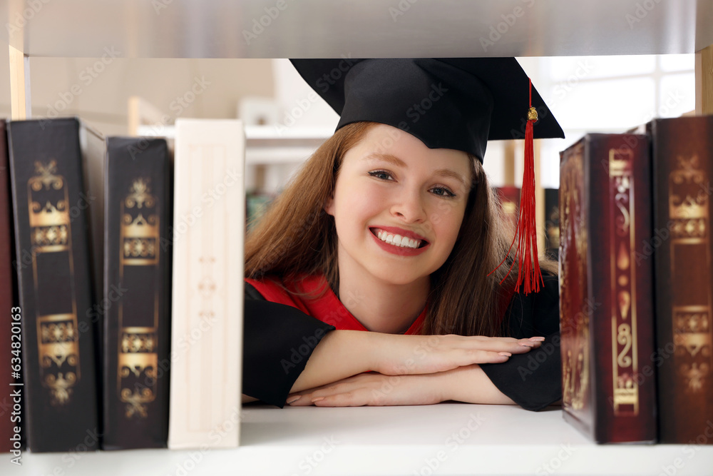 Female graduate student near bookshelf in library, closeup