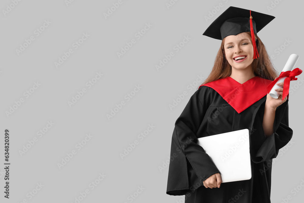 Female graduate student with diploma and laptop on grey background