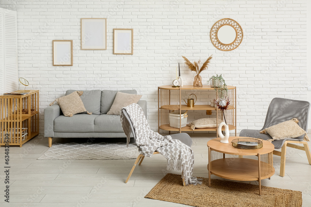 Modern living room interior with grey sofa, armchairs and coffee table