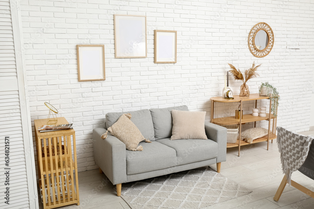 Modern living room interior with grey sofa and shelving units