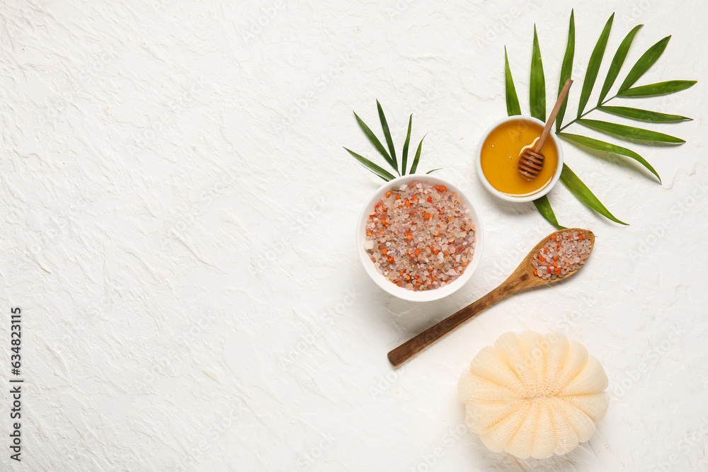 Composition with sea salt, honey, sponge and palm leaves on light background