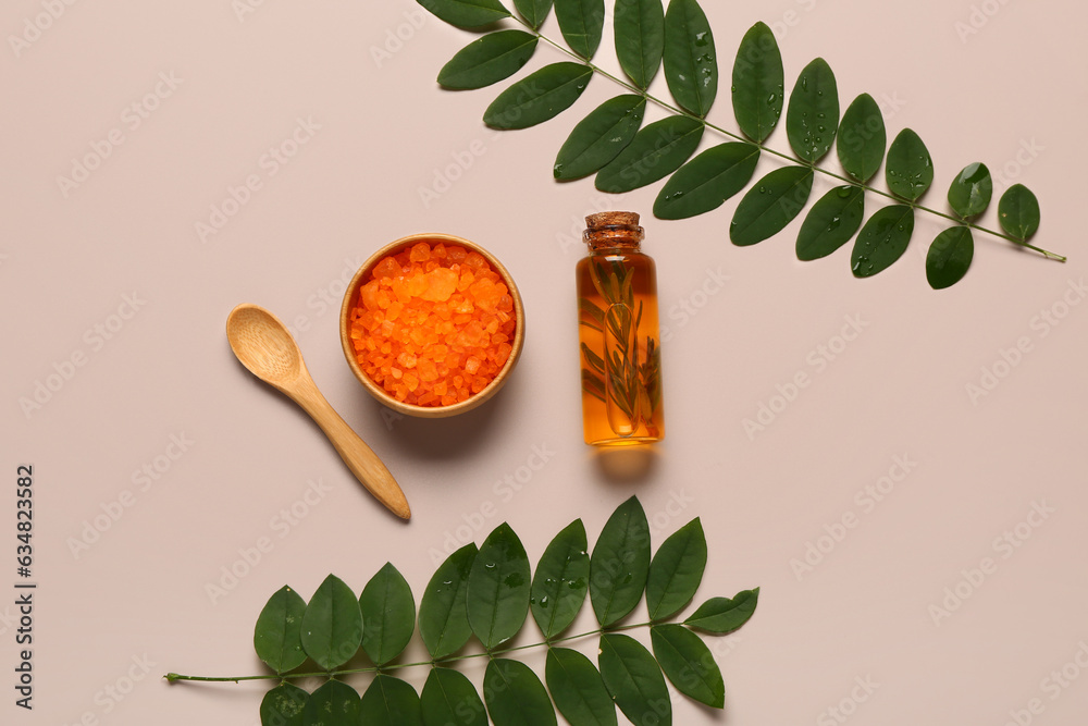 Bottle of cosmetic oil with leaves and sea salt on grey background