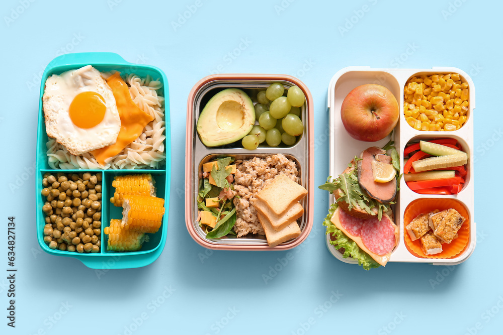 Many lunchboxes with different delicious food on blue background