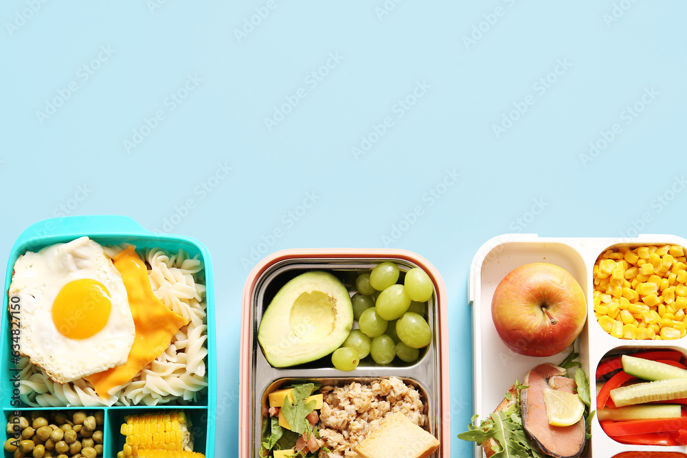 Many lunchboxes with different delicious food on blue background