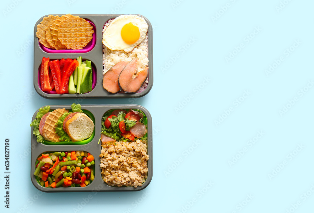 Lunchboxes with different delicious food on blue background