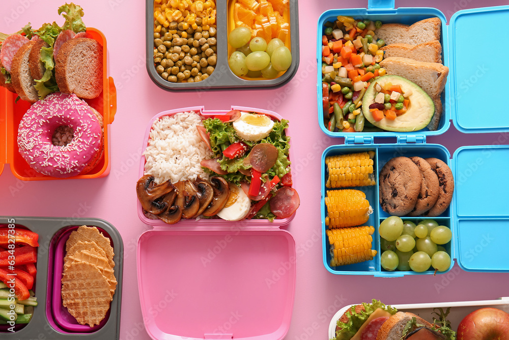 Many lunchboxes with different delicious food on pink background