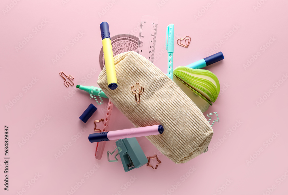 Different flying stationery on pink background