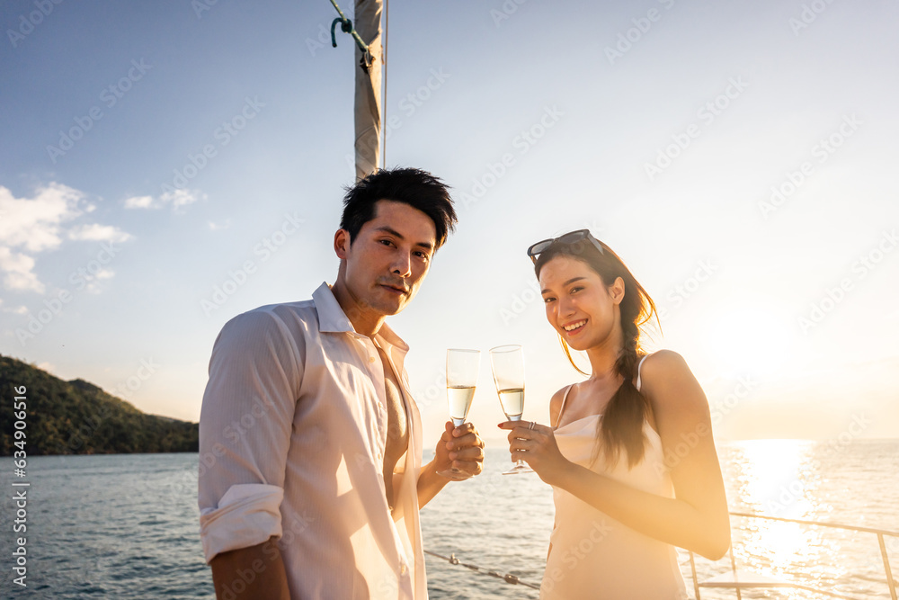 Asian beautiful couple drinking champagne while having party in yacht. 