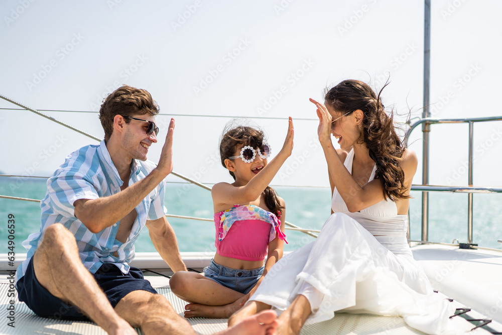 Caucasian happy family sitting on deck of yacht while yachting outdoor. 