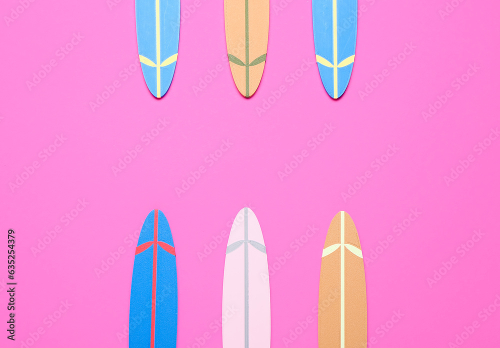 Different mini surfboards on pink background