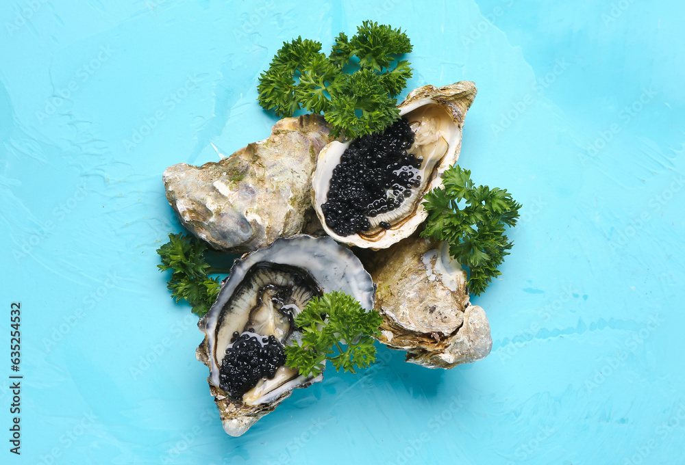 Tasty oysters with black caviar on blue background