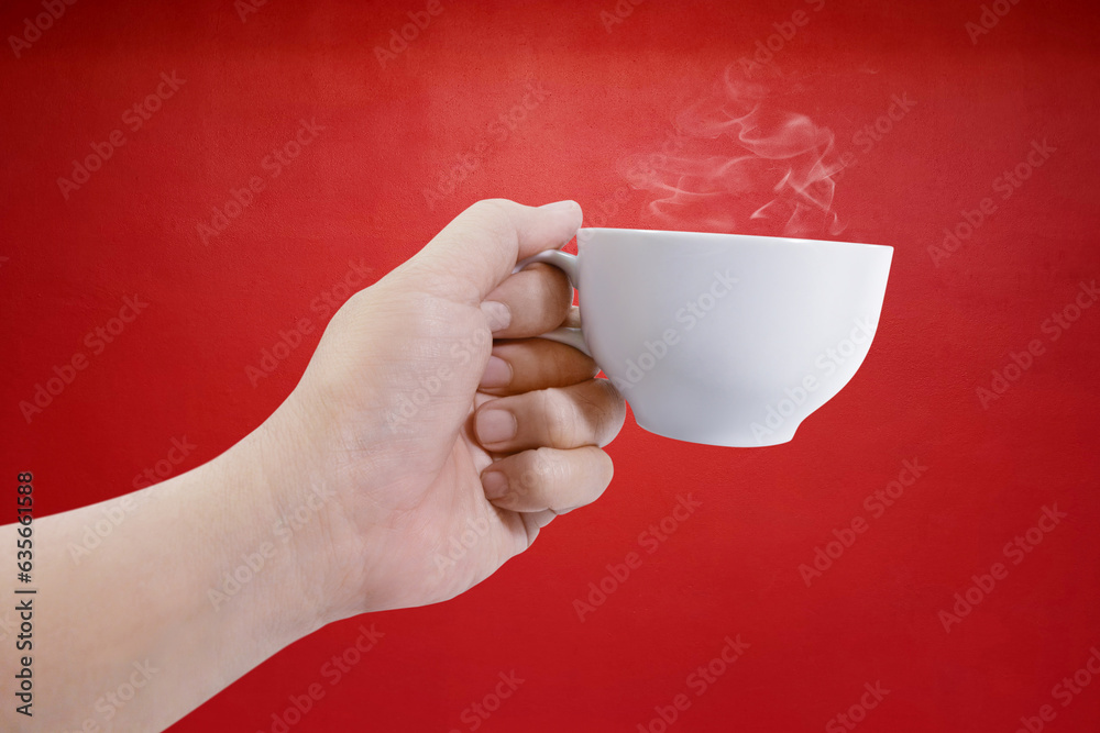 hand holding white coffee cup with red background